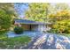 A single-story home with painted brick and a carport nestled among mature trees, offering shade and curb appeal at 8596 Timberlane Dr, Douglasville, GA 30134