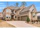 A spacious two-story brick home featuring an attached two-car garage and neatly arranged landscaping at 909 Sunny Meadows Lane, Marietta, GA 30062