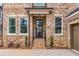 Close-up of the front entrance with a modern glass-paneled door, brick steps, and manicured shrubs at 909 Sunny Meadows Lane, Marietta, GA 30062