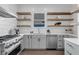 Bright kitchen featuring stainless steel appliances, open shelving, and elegant countertops at 909 Sunny Meadows Lane, Marietta, GA 30062