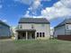 Rear of house featuring a covered porch, neutral siding, a well-maintained lawn, and neighbor homes at 556 Paden Ridge Way, Lawrenceville, GA 30044