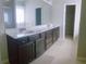 Bathroom vanity with dual sinks, quartz countertop and dark wood cabinets with a view of the shower at 556 Paden Ridge Way, Lawrenceville, GA 30044