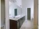 Bathroom featuring dark vanity with double sinks and large mirror at 556 Paden Ridge Way, Lawrenceville, GA 30044