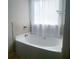 Bathroom features a modern tub with stylish fixtures and a white shower curtain at 556 Paden Ridge Way, Lawrenceville, GA 30044