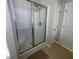 Bathroom featuring a sleek glass shower with modern fixtures, and two crisp white doors at 556 Paden Ridge Way, Lawrenceville, GA 30044