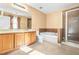 Bright bathroom boasts double vanity, soaking tub, and glass enclosed shower at 6533 Waterford Sw St, Atlanta, GA 30331