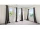 Bright bedroom with three windows dressed in decorative curtains and neutral carpet at 6533 Waterford Sw St, Atlanta, GA 30331