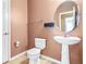 This powder room features a pedestal sink, oval mirror, and neutral walls at 6533 Waterford Sw St, Atlanta, GA 30331