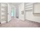 Spacious closet with built in shelving units, neutral paint, and light-colored carpet at 6533 Waterford Sw St, Atlanta, GA 30331