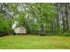 Spacious backyard with a storage shed, mature trees, and ample space for outdoor activities at 2238 Roseberry Ln, Grayson, GA 30017