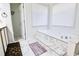 Bright bathroom featuring a luxurious soaking tub with marble accents and marble floors at 2238 Roseberry Ln, Grayson, GA 30017