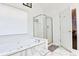Well-lit bathroom with a glass-enclosed shower and soaking tub with marble accents at 2238 Roseberry Ln, Grayson, GA 30017