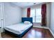 Simple bedroom with hardwood floors, a blue bed frame, and natural light from a window at 2238 Roseberry Ln, Grayson, GA 30017