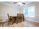 Well-lit dining area featuring a classic table setting, hardwood floors, and a serene window view at 2238 Roseberry Ln, Grayson, GA 30017