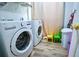 Bright laundry room featuring a washer and dryer, wood look floors, and colorful -size chairs at 2238 Roseberry Ln, Grayson, GA 30017
