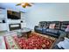Living room with a leather sofa, glass coffee table, built in shelves, and a patterned rug at 2238 Roseberry Ln, Grayson, GA 30017