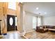 Bright, open-concept living area with large windows, hardwood floors, and a glimpse of a staircase and front entrance at 2238 Roseberry Ln, Grayson, GA 30017