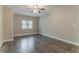 Spacious bedroom featuring wood floors, neutral paint, a ceiling fan, and natural light from the windows at 2682 Cavalier Dr, Decatur, GA 30034