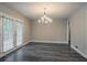 Elegant dining area featuring a modern chandelier, wood-look floors, and natural light from large French doors at 2682 Cavalier Dr, Decatur, GA 30034