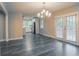Open-concept dining area with modern chandelier, wood-look floors, and seamless access to the updated kitchen at 2682 Cavalier Dr, Decatur, GA 30034