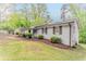 Quaint light brick house with manicured shrubs, set on a gently sloping lawn against a backdrop of mature trees at 2682 Cavalier Dr, Decatur, GA 30034