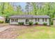 Charming single-story home featuring a light brick exterior and an arched entryway nestled in a lush green landscape at 2682 Cavalier Dr, Decatur, GA 30034