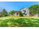 A home's large, grassy backyard features a mix of sun and shade, bordered by a wooden fence and mature trees at 7194 Oakwood Cir, Rex, GA 30273