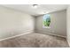 Bedroom with neutral carpet, paint, and a window allowing natural light to fill the room at 7194 Oakwood Cir, Rex, GA 30273