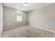 Bedroom with neutral carpet, paint, and a window allowing natural light to fill the room at 7194 Oakwood Cir, Rex, GA 30273
