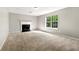 Spacious living room featuring neutral carpet, paint, a fireplace, and a large window at 7194 Oakwood Cir, Rex, GA 30273