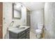 Neutral bathroom features tile walls, a pedestal sink, a mirror, and a toilet at 958 Winburn Dr, Atlanta, GA 30344