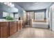 Elegant bathroom featuring a soaking tub, glass-enclosed shower, double vanity, and neutral tile flooring for a spa-like experience at 415 Eldridge Dr, Suwanee, GA 30024