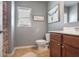 Cozy bathroom with a cherry wood vanity, a white toilet, and a shower/tub combination, blending functionality and style at 415 Eldridge Dr, Suwanee, GA 30024