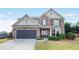 Charming two-story home with stone and siding exterior, landscaped lawn, and attached two-car garage at 415 Eldridge Dr, Suwanee, GA 30024