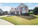 Inviting two-story home featuring a well-manicured lawn, stone accents, and a two-car attached garage at 415 Eldridge Dr, Suwanee, GA 30024