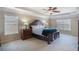 Spacious primary bedroom featuring a tray ceiling, plush carpet, and abundant natural light from two large windows at 415 Eldridge Dr, Suwanee, GA 30024