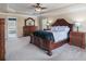 Large primary bedroom with tray ceiling, carpet, and dark wood furniture creating a luxurious and inviting retreat at 415 Eldridge Dr, Suwanee, GA 30024