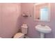 Small powder room features a white pedestal sink, toilet, and a light purple wall at 539 Riverbirch Trce, Stone Mountain, GA 30087