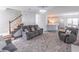 Comfortable living room with gray sofa, stairs, and an open view into the kitchen area at 539 Riverbirch Trce, Stone Mountain, GA 30087