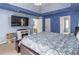 Main bedroom features blue painted walls, tv, and views into the ensuite bathroom at 539 Riverbirch Trce, Stone Mountain, GA 30087