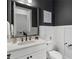 Stylish bathroom features a modern vanity with a white countertop and dark fixtures, complemented by elegant wall decor at 825 Maplewood Dr, Roswell, GA 30075