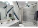 This bathroom showcases blue stripes, modern finishes, and a combined shower-tub at 825 Maplewood Dr, Roswell, GA 30075