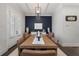 Airy dining room with decorative accent wall, modern light fixture, and seating for eight people at 825 Maplewood Dr, Roswell, GA 30075