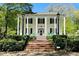 Two-story historic home with white columns, black shutters, and rocking chairs on the front porch at 825 Maplewood Dr, Roswell, GA 30075