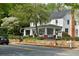 Charming home with a welcoming porch, stone wall, and lush landscaping, adding to its curb appeal at 825 Maplewood Dr, Roswell, GA 30075