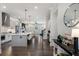 Open-concept kitchen features stainless steel appliances, white cabinetry, and a large island with seating, flowing into living area at 825 Maplewood Dr, Roswell, GA 30075