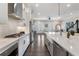 Modern kitchen boasts white countertops, stainless steel appliances, and a view of the living area through shuttered doors at 825 Maplewood Dr, Roswell, GA 30075