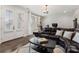 Comfortable living room with a dark leather sectional, neutral rug, and windows for natural light at 825 Maplewood Dr, Roswell, GA 30075