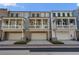 Townhome exterior featuring balconies, garage doors, and well-maintained landscaping at 825 Maplewood Dr, Roswell, GA 30075