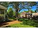 Town square with charming buildings, manicured lawns, and mature trees at 825 Maplewood Dr, Roswell, GA 30075